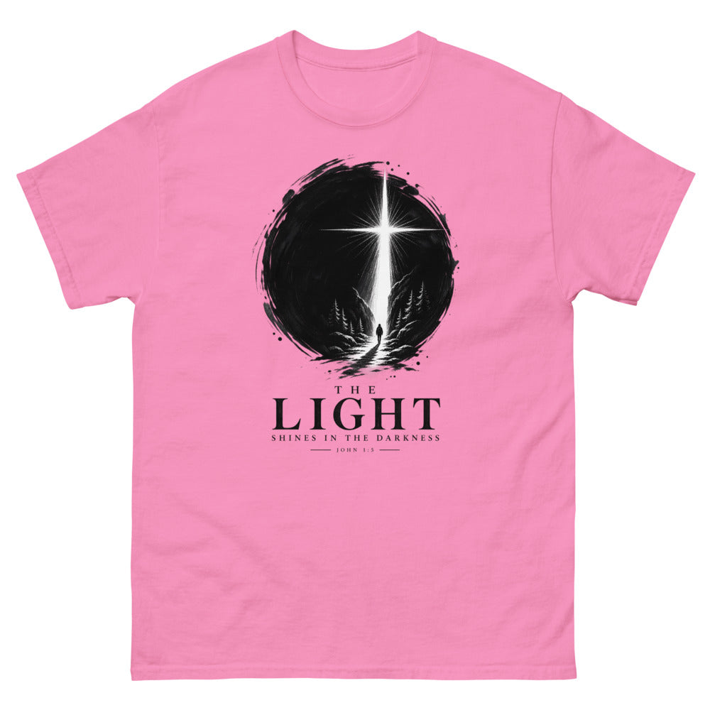 Ink circle with a figure walking toward a blazing cross reading The Light Shines In The Darkness on a Azalea shirt