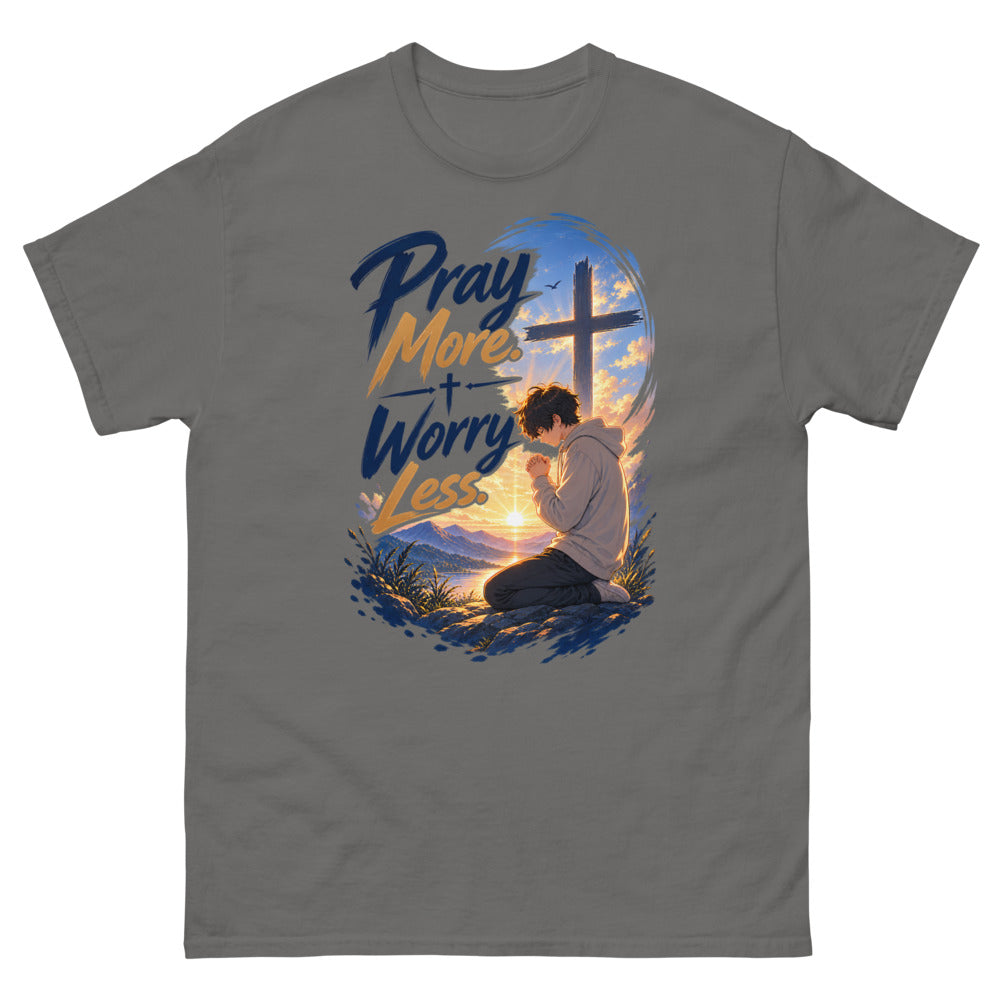 Anime boy kneeling in prayer at sunrise beneath a cross with the words Pray More Worry Less on a Charcoal shirt