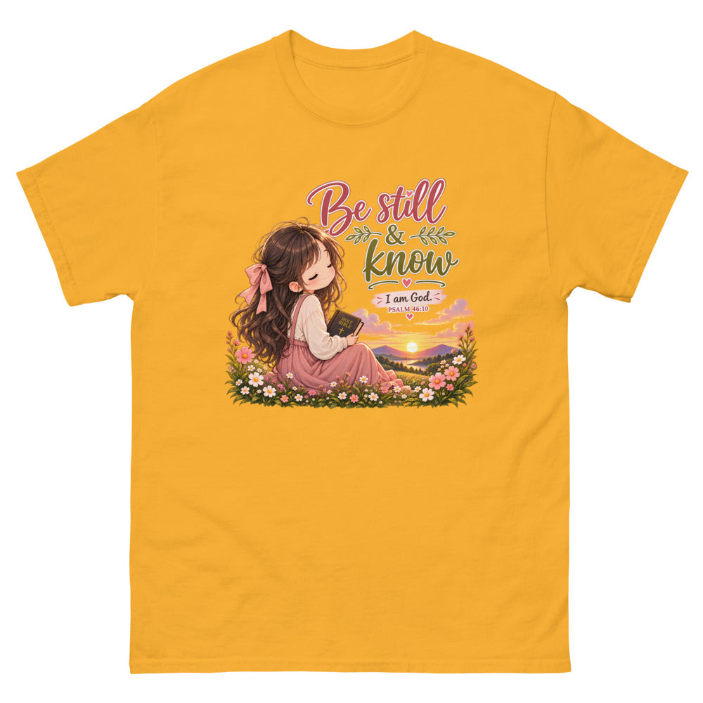 Chibi girl in a flower field holding a Bible with the words Be Still And Know on a Gold shirt