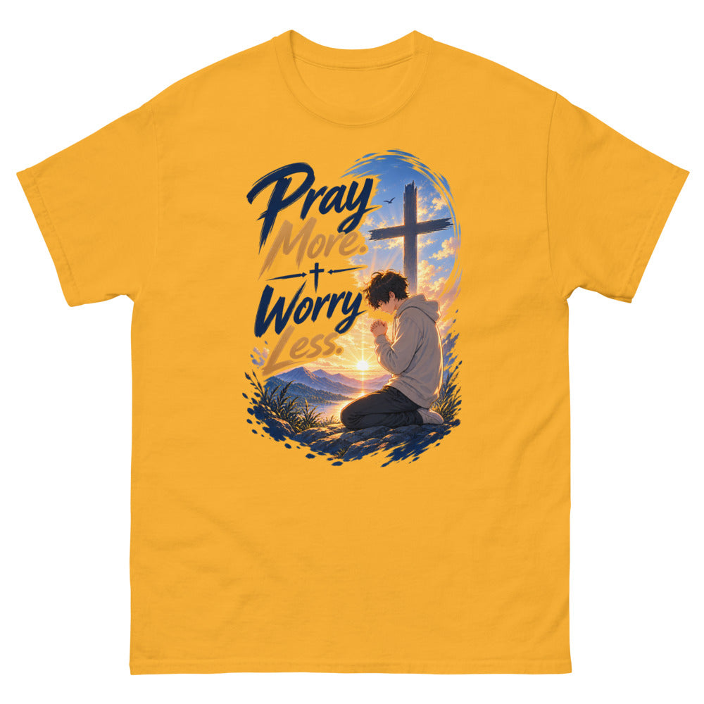 Anime boy kneeling in prayer at sunrise beneath a cross with the words Pray More Worry Less on a Gold shirt