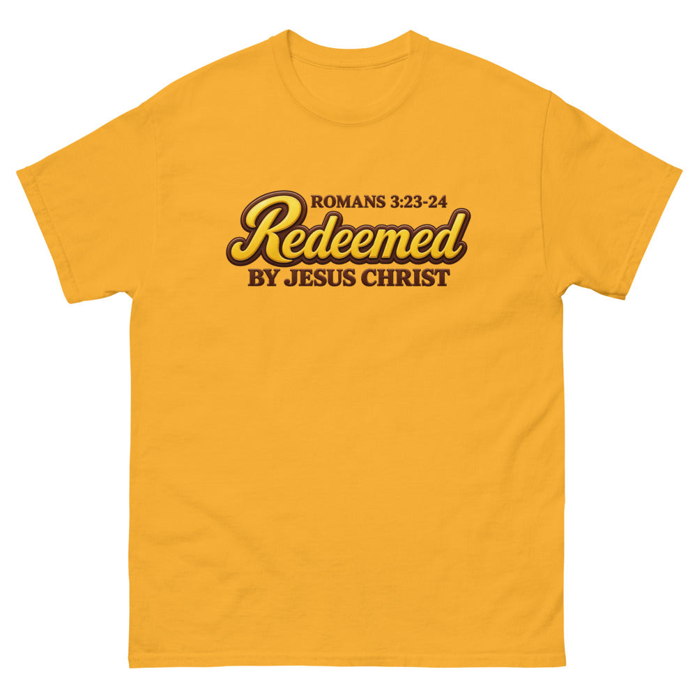 Glossy gold and brown candy script reading Redeemed by Jesus Christ, Romans 3:23-24 on a Gold shirt