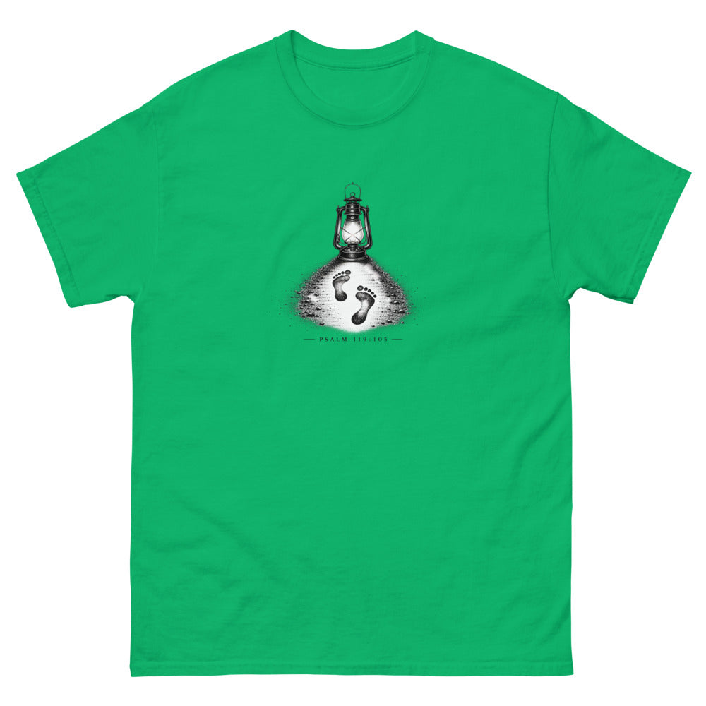 Stippled lantern lighting two footprints in sand with Psalm 119:105 on a Irish Green shirt