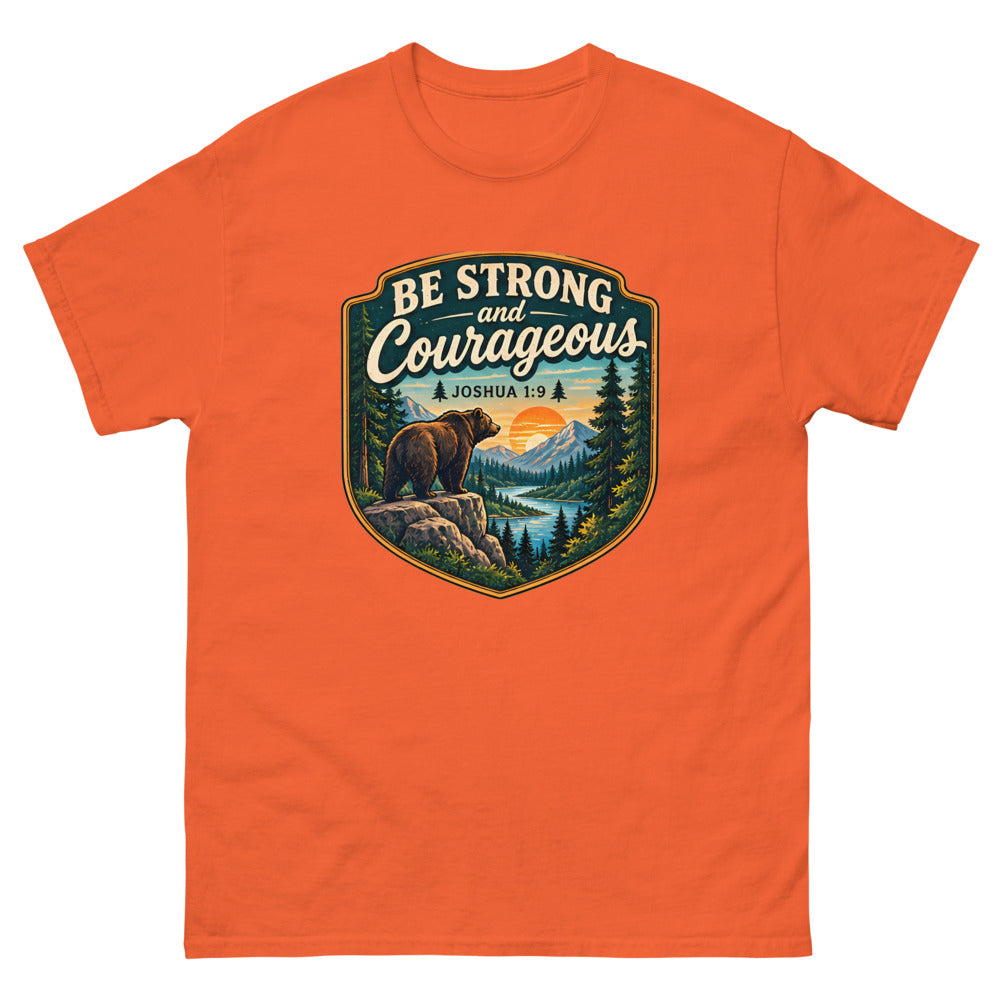 Shield badge with a bear on a rock reading Be Strong And Courageous on a Orange shirt
