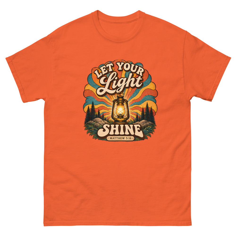 Retro lantern glowing against sunburst rays reading Let Your Light Shine on a Orange shirt