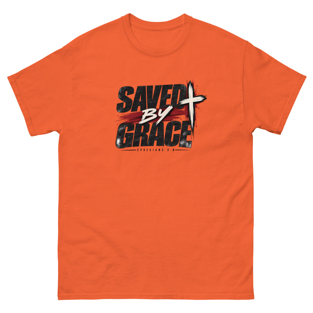 Streetwear lettering with a red brush stroke and cross reading Saved By Grace on a Orange shirt