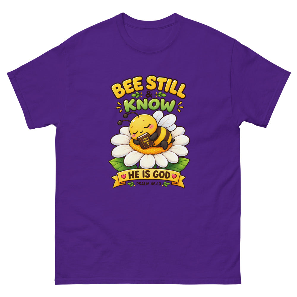 Cartoon bee sleeping on a daisy with a Bible and the words Bee Still And Know on a Purple shirt