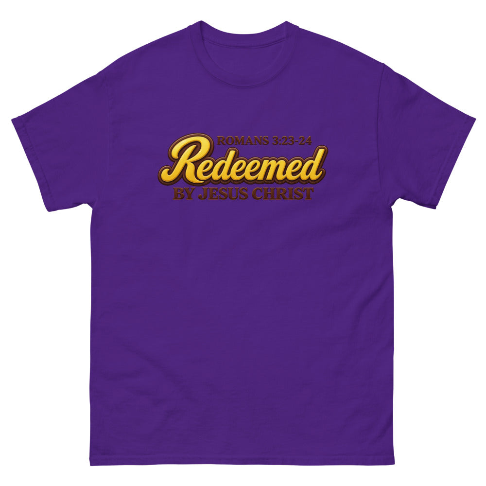 Glossy gold and brown candy script reading Redeemed by Jesus Christ, Romans 3:23-24 on a Purple shirt