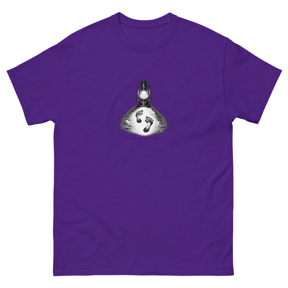 Stippled lantern lighting two footprints in sand with Psalm 119:105 on a Purple shirt