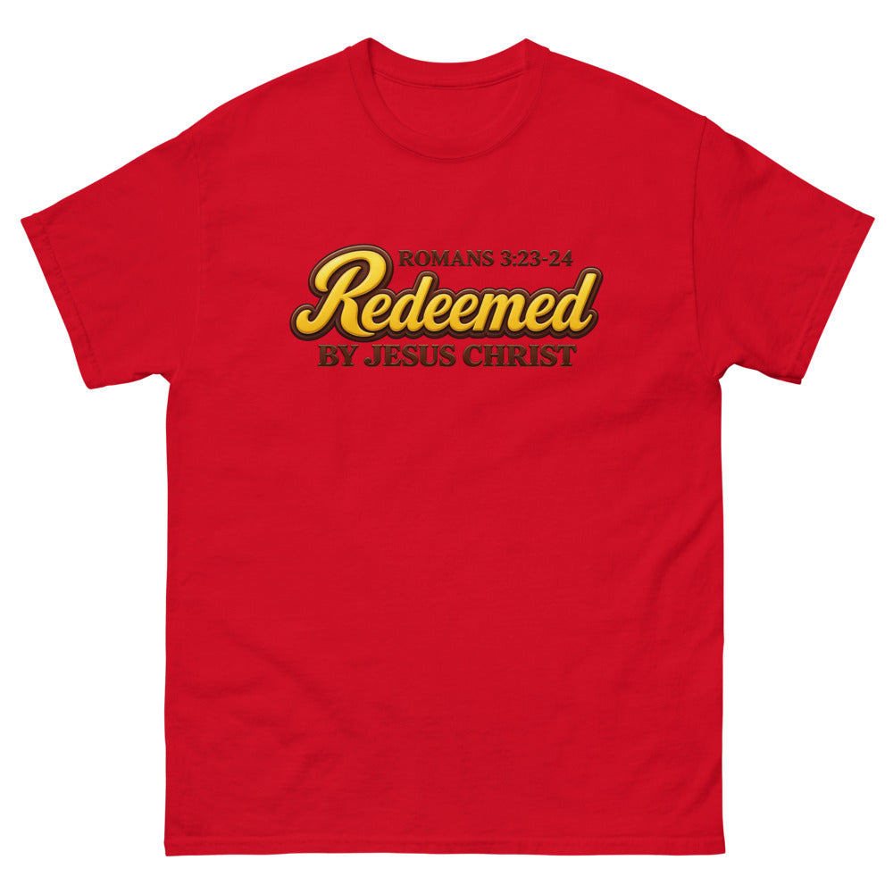 Glossy gold and brown candy script reading Redeemed by Jesus Christ, Romans 3:23-24 on a Red shirt