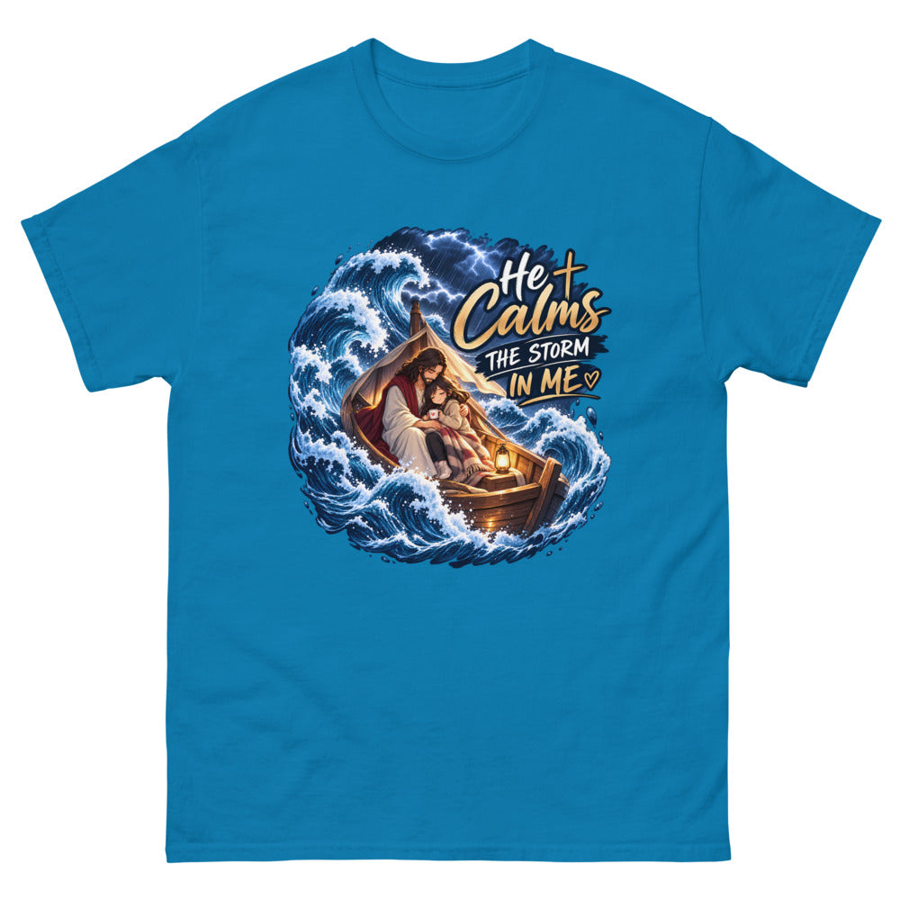 Jesus holding a young woman in a boat during a storm with the words He Calms The Storm In Me on a Sapphire shirt