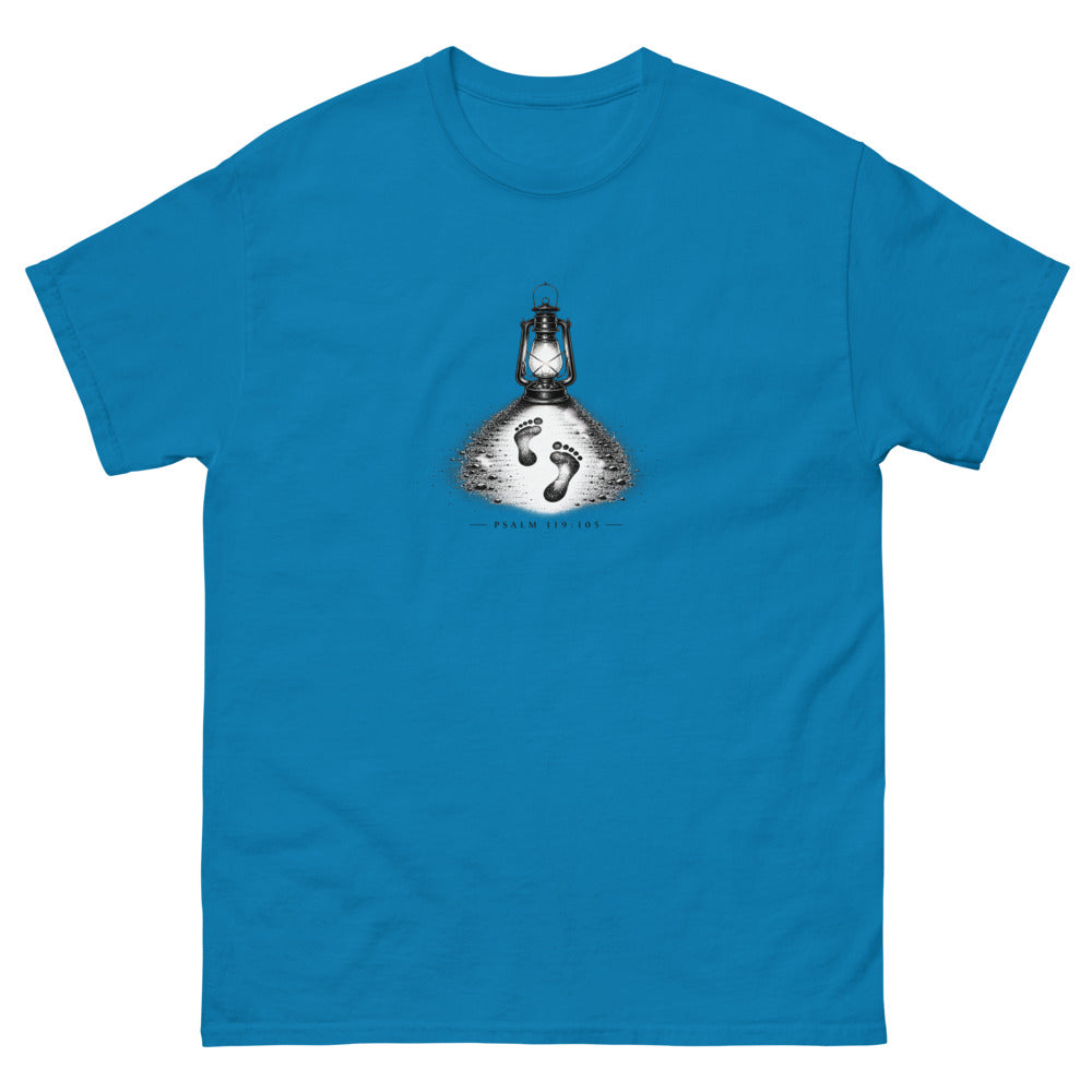 Stippled lantern lighting two footprints in sand with Psalm 119:105 on a Sapphire shirt